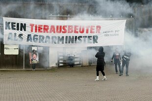 Ein Transparent mit der Aufschrift "Kein Tierausbeuter als Agrarminister" hängt an einem Stall
