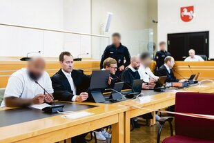 Der angeklagte Staatsanwalt und ein weiterer Angeklagte sitzen zum Auftakt eines Prozesses wegen Bestechlichkeit und Verletzung des Dienstgeheimnisses in einem Saal des Landgerichts Hannover.